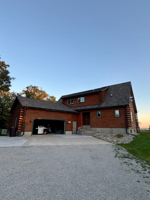 Log home exterior with a garage and warm wood finish